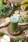Green smoothie surrounded by ingredients — Stock Photo