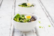 Two bowls of Ramen soup with egg, broccoli, noodles, shitake mushrooms and spring onions — Stock Photo