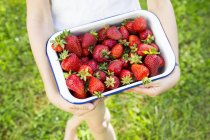 Fille tenant bol avec des fraises, vue partielle — Photo de stock