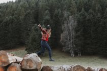 Junge Frau balanciert auf Baumstämmen — Stockfoto