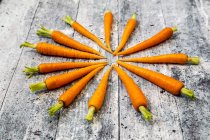 Baby carrots on wooden background — Stock Photo