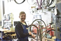 Bicycle mechanic in his repair shop, portrait — Stock Photo