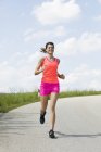 Joven mujer corriendo al aire libre - foto de stock