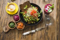 Insalata colorata decorata su piatto di legno con caffè, acqua e frullato sul lato — Foto stock