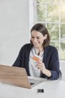 Lachende Geschäftsfrau mit Laptop am Schreibtisch — Stockfoto