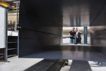 Dois homens com prancheta falando no chão da fábrica — Fotografia de Stock