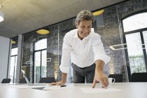 Geschäftsmann arbeitet im modernen Büro mit Dokumenten auf dem Schreibtisch — Stockfoto