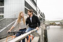 Coppia sorridente con biciclette in città — Foto stock