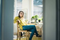 Portrait de créatrice de mode assise à son bureau dans son studio — Photo de stock