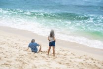 Pareja mayor en la playa mirando al mar - foto de stock
