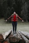 Junge Frau balanciert auf Baumstämmen — Stockfoto