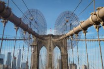 Usa, new york, brooklyn, close up von brooklyn bridge metallseilen und bögen mit amerikanischer flagge auf der spitze — Stockfoto