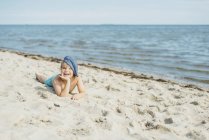 Porträt eines glücklichen Jungen, der am Strand liegt — Stock Photo