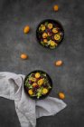 Bowl of mixed green salad with red cabbage, kumquat and pomegranate seeds — Stock Photo