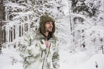 Man in camouflage jacket in winter forest — Stock Photo
