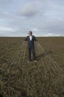Empresário de pé em um campo amarrado a cordas — Fotografia de Stock