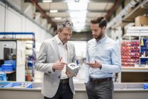 Businessmen during meeting with a product in production hall — Stock Photo