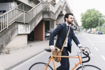 Бізнесмен з велосипедом ходьба по вулиці — стокове фото