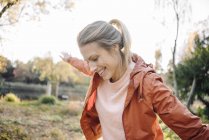 Retrato de una joven feliz balanceándose en el parque otoñal - foto de stock
