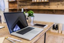 Laptop and tablet on wooden table at home — Stock Photo