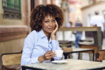 Porträt einer lächelnden Frau mit Afro-Frisur im Café — Stockfoto