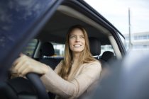 Porträt einer lächelnden jungen Frau im Auto — Stockfoto