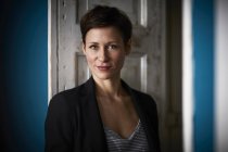 Porträt einer Geschäftsfrau, die sich in die Tür lehnt — Stockfoto