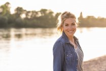 Ritratto di donna bionda sul lungofiume la sera — Foto stock