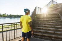 Young athlete jogging up stairs in the city — Stock Photo