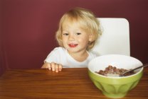 Portrait de petit garçon souriant à la table du petit déjeuner — Photo de stock