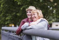 Feliz abuela y nieta apoyadas juntas en la barandilla - foto de stock