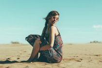 Молода жінка сидить у пустельному пейзажі — стокове фото