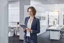 Businesswoman using tablet in office — Stock Photo