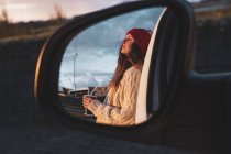 Islândia, jovem mulher com café para ir ao pôr do sol, espelhada no espelho da asa — Fotografia de Stock