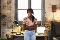 Portrait de jeune femme souriante debout devant le bureau dans un loft — Photo de stock