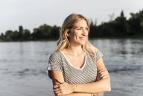 Портрет блондинки на берегу реки вечером — стоковое фото