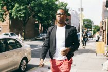США, Нью-Йорк, Бруклін, людина ходьба на вулиці, тримаючи чашку кави — стокове фото