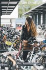 Young woman with bicycle using cell phone in the city — Stock Photo