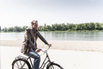 Reifer Mann mit Fahrrad am Rheinufer — Stockfoto