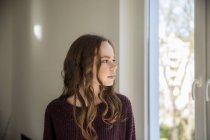 Teenagermädchen schaut aus dem Fenster und träumt — Stockfoto