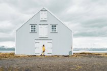 Iceland, woman with guitar walking at lonely house — Stock Photo