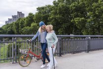 Grandmother and granddaughter strolling on a bridge — Stock Photo