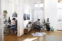 Paar sitzt zu Hause und sortiert Akten mit Dokumenten — Stockfoto