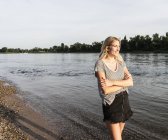 Donna bionda sul lungofiume la sera — Foto stock