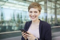 Portrait of blond businesswoman using smartphone — Stock Photo