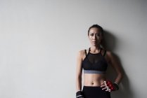 Retrato de mujer boxeadora confiada contra pared gris - foto de stock