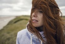 Femme rousse profiter de l'air frais à la plage — Photo de stock