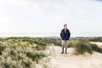 Hombre de pie en el paisaje de dunas - foto de stock