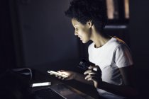 Junge afrikanisch-amerikanische Frau mit Kreditkarte, die nachts von zu Hause aus online einkauft — Stockfoto