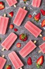 Homemade strawberry ice lollies and strawberries on marble — Stock Photo